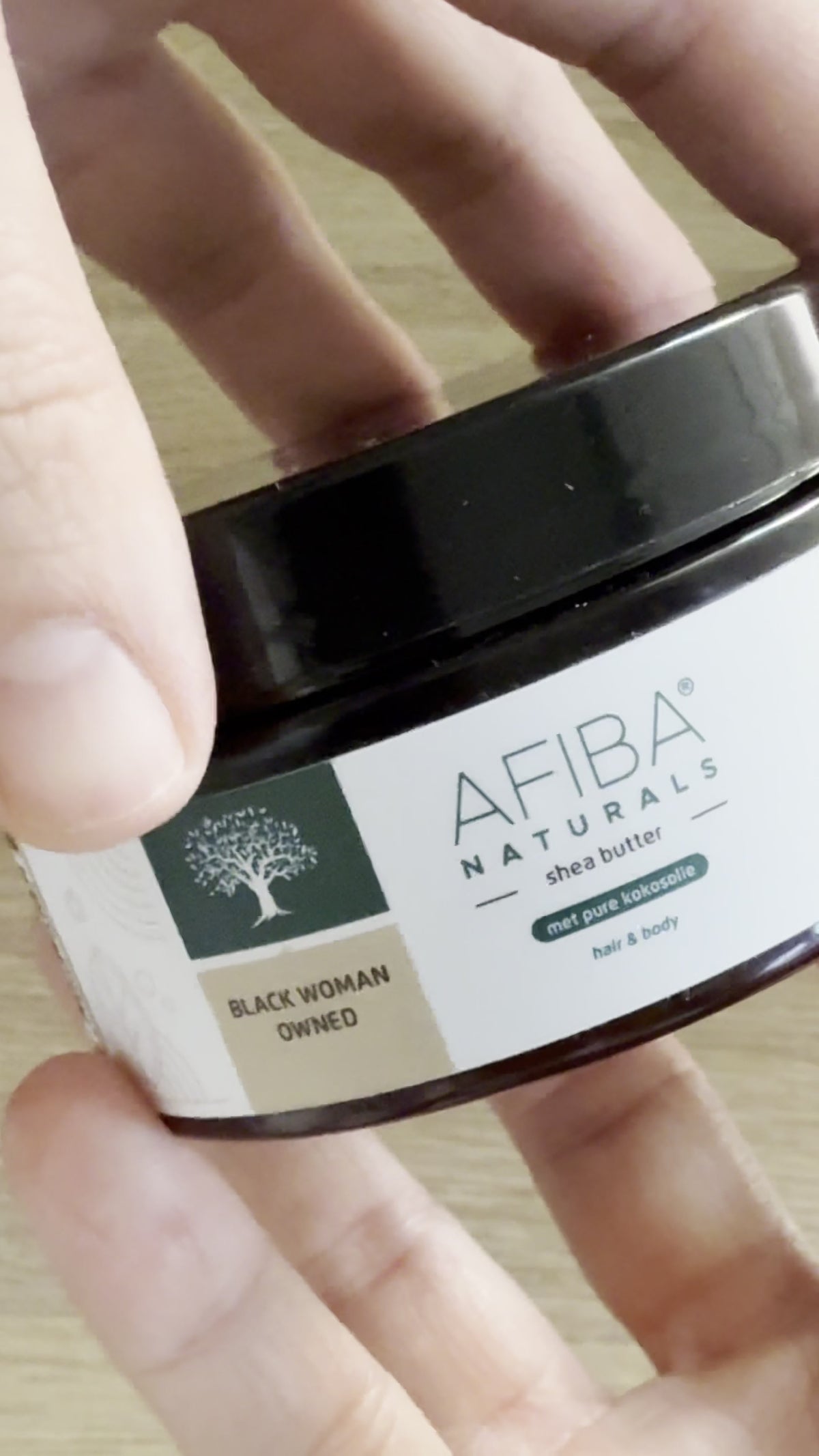 Afiba Naturals Shea Butter met Coronie kokosolie in de hand